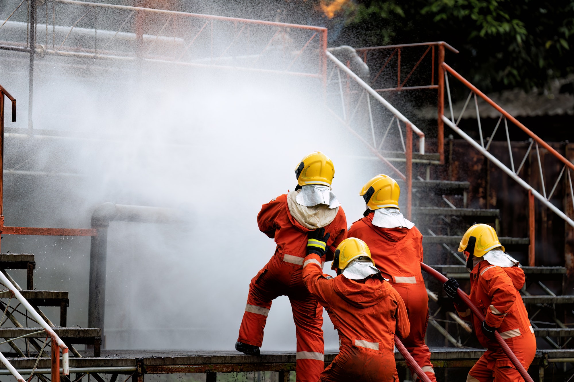 Fire fighter team on training with gas and oil fire at pipe line and valve spray jet water