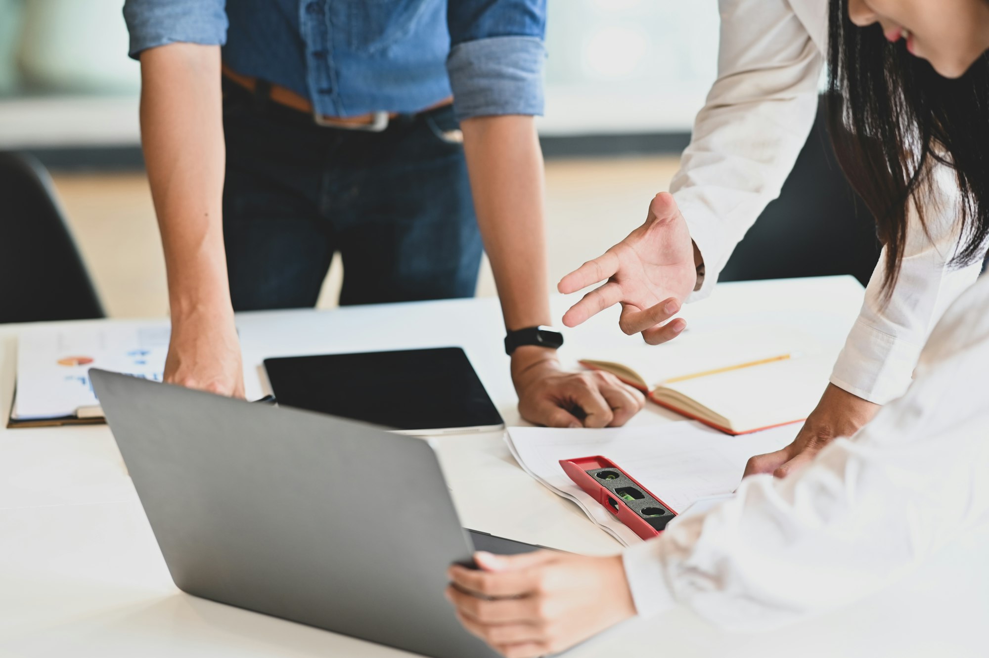 Cropped development team discussing about structural systems of engineering at the meeting desk.