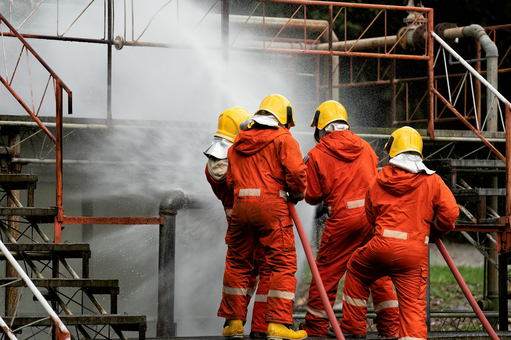 Fire fighter team on training with gas and oil fire at pipe line and valve spray jet water